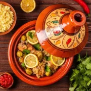 Traditional Moroccan tagine served with tender lamb, prunes, and couscous, showcasing rich spices and vibrant colors.