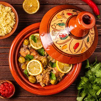 Traditional Moroccan tagine served with tender lamb, prunes, and couscous, showcasing rich spices and vibrant colors.